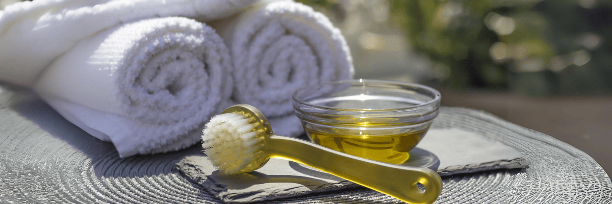 Badeöl mit Duschbürste und Handtüchern